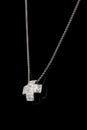 Precious platinum chain with cross diamonds on black background.