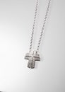 Precious platinum chain with cross diamonds on gray background.