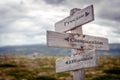 precise compassion effortless text engraved on old wooden signpost outdoors in nature Royalty Free Stock Photo