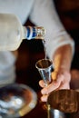 Pouring vodka into jigger with precision in a dimly lit bar setting Royalty Free Stock Photo