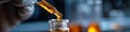 Precisely dispensing a golden liquid: Scientist's hand with a dropper in a mysterious lab. Royalty Free Stock Photo
