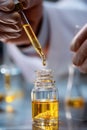 Precisely dispensing a golden liquid: Scientist's hand with a dropper in a mysterious lab. Royalty Free Stock Photo