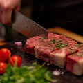 Precision in cooking Chefs hands cutting a large beef portion