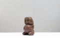 Precolombian figurine made out of clay represents the goddes of fertility in front of white background