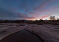 Predawn light paints the sky above rain filled pools on Gooseberry Mesa in Southern Utah Royalty Free Stock Photo