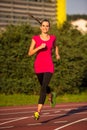 Preety young woman running on a track