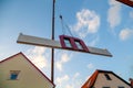 Prefabricated house part with two red windows is hoisted between two houses by the mobile crane for assembly Royalty Free Stock Photo