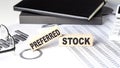 PREFERRED STOCK - text on a wooden block with chart and notebook