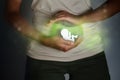 Pregnancy and abortion.The paper-cut silhouette of an embryo in a woman`s hands is surrounded by a greenish glow - an allegory of Royalty Free Stock Photo