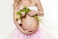 Pregnancy. Exposed belly and hands of a pregnant woman. Spring flowers. Tulips. Royalty Free Stock Photo