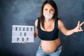 Pregnancy concept - beautiful pregnant woman popping bubble gum and being happy