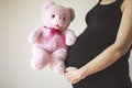 Pregnancy concept. Pregnant woman holding teddy bear toy in his hand, studio isolated Royalty Free Stock Photo