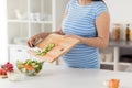 Close up of pregnant woman cooking food at home Royalty Free Stock Photo