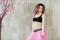 Pregnancy fitness and sport concept happy pregnant woman near the pink sakura tree. ballet dancer on gray background Royalty Free Stock Photo
