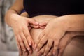 Pregnancy girl. Mom and Dad with hands on the belly of a pregnant girl, Heart of hands by couple on pregnant belly Royalty Free Stock Photo