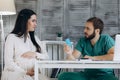 Pregnancy, gynecology, medicine, health care and people concept - gynecologist doctor and pregnant woman meeting at hospital. Royalty Free Stock Photo