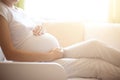 Pregnancy. Happy pregnant woman lying in bed and touching her belly at home Royalty Free Stock Photo