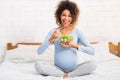 Pregnancy, healthy food concept. Afro woman eating vegetable salad Royalty Free Stock Photo