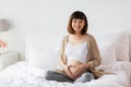 Happy pregnant woman making heart gesture in bed Royalty Free Stock Photo