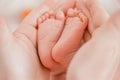 Pregnancy, maternity, preparation and expectation motherhood, giving birth concept. Newborn baby feet in hands of mommy Royalty Free Stock Photo