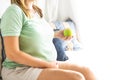 Pregnancy, motherhood- close up of happy pregnant woman with green apple