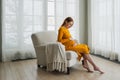Pregnancy motherhood people expectation future. Pregnant woman with big belly sitting on chair near window at home. Girl Royalty Free Stock Photo