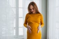 Pregnancy motherhood people expectation future. Pregnant woman with big belly standing near window at home. Girl hugging Royalty Free Stock Photo