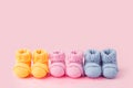 Pregnancy motherhood perenthood concept, Three pairs of baby booties on pink background, baby shower, first birthday party banner Royalty Free Stock Photo