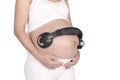 Pregnancy and music. belly of pregnant woman and headphones on t