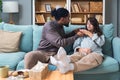 Pregnancy and people concept - happy African man hugging pregnant woman at home. Young couple sitting on sofa, husband support and Royalty Free Stock Photo