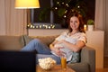 Happy smiling pregnant woman watching tv at home Royalty Free Stock Photo