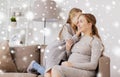 Happy pregnant woman and girl gossiping at home Royalty Free Stock Photo