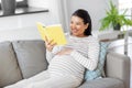 happy pregnant woman reading book at home Royalty Free Stock Photo