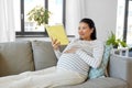 happy pregnant woman reading book at home Royalty Free Stock Photo