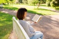 Happy pregnant asian woman reading book at park Royalty Free Stock Photo