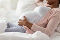 Happy pregnant african woman lying in bed at home Royalty Free Stock Photo