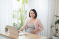 Pregnancy, people and rest concept - close up of happy pregnant woman eating yogurt for breakfast at home Royalty Free Stock Photo