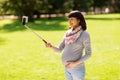 Happy pregnant asian woman taking selfie at park Royalty Free Stock Photo