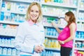 Pregnancy and pharmaceutics. pharmaceutist with pregnant on background at store