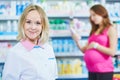 Pregnancy and pharmaceutics. pharmaceutist with pregnant on background at store Royalty Free Stock Photo