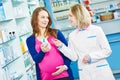 Pregnancy and pharmaceutics. pharmaceutist with pregnant at pharmacy store Royalty Free Stock Photo