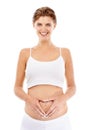 Pregnancy, portrait and mom with a heart on her stomach in a studio for prenatal care, love and happiness. Wellness