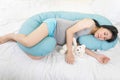 Pregnancy, rest, people and expectation concept - Happy Pregnant woman sleeping peacefully with body pillow and hug a white bear