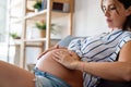 Pregnancy, skin care and maternity concept. Pregnant woman applying stretch mark cream to belly Royalty Free Stock Photo