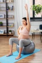 Pregnant woman exercising on fitness ball at home Royalty Free Stock Photo