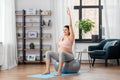 Pregnant woman exercising on fitness ball at home Royalty Free Stock Photo