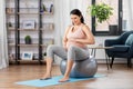 Pregnant woman exercising on fitness ball at home Royalty Free Stock Photo