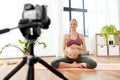 Pregnant woman or yoga blogger with camera at home Royalty Free Stock Photo