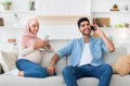 Pregnancy and technology concept. Young muslim husband and his pregnant wife resting with smartphones at home Royalty Free Stock Photo