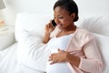 Happy pregnant woman calling on smartphone at home Royalty Free Stock Photo